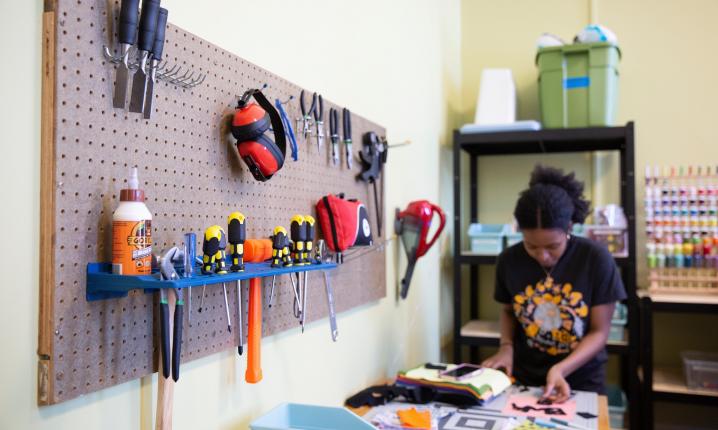 A student working in the new craft space with tools around her.